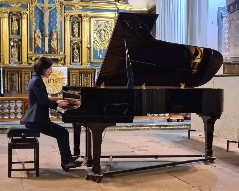 Mariam, seated about to play, at the St Chad's piano 