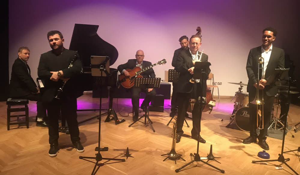 The septet on stage, about to play