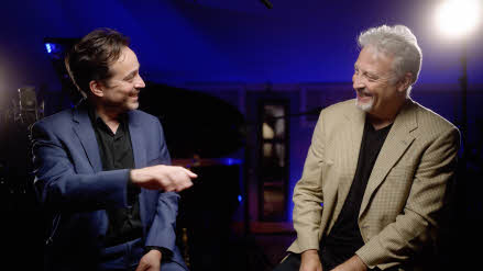 Jason Rebello and Tim Garland seated, three-quarters facing each other and in conversation