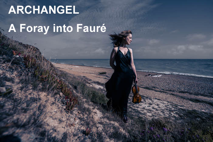 Fenella stands on a sand dune near the sea, wearing a long, black dress and holding her violin in her left hand