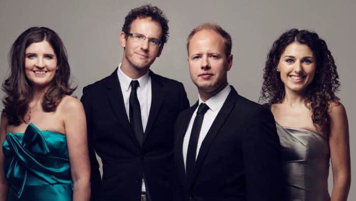 The Quartet in formal wear standing without their instruments.